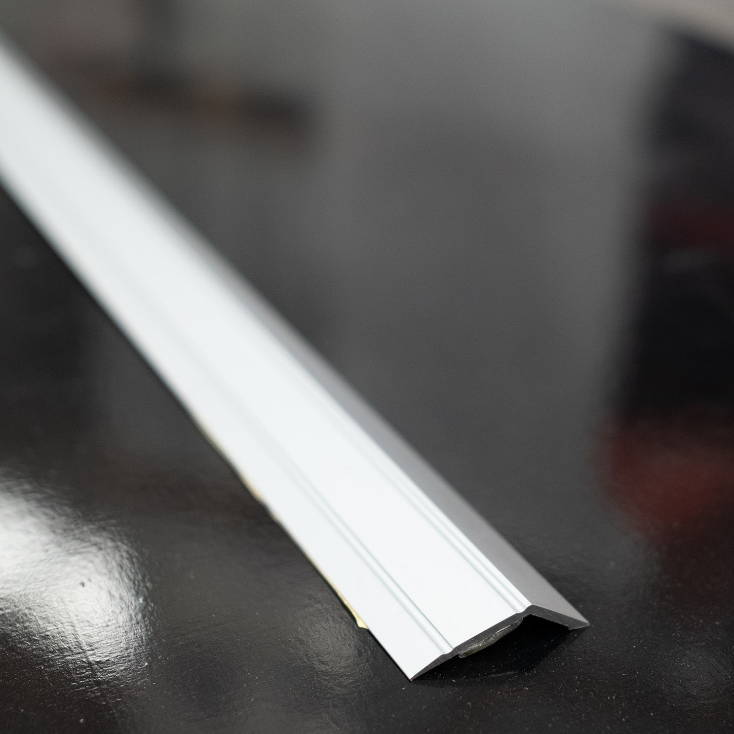 J & A Flooring Tile Ramp Reducer chrome Colour Self Adhesive, an accessory used when installing laminate wood flooring